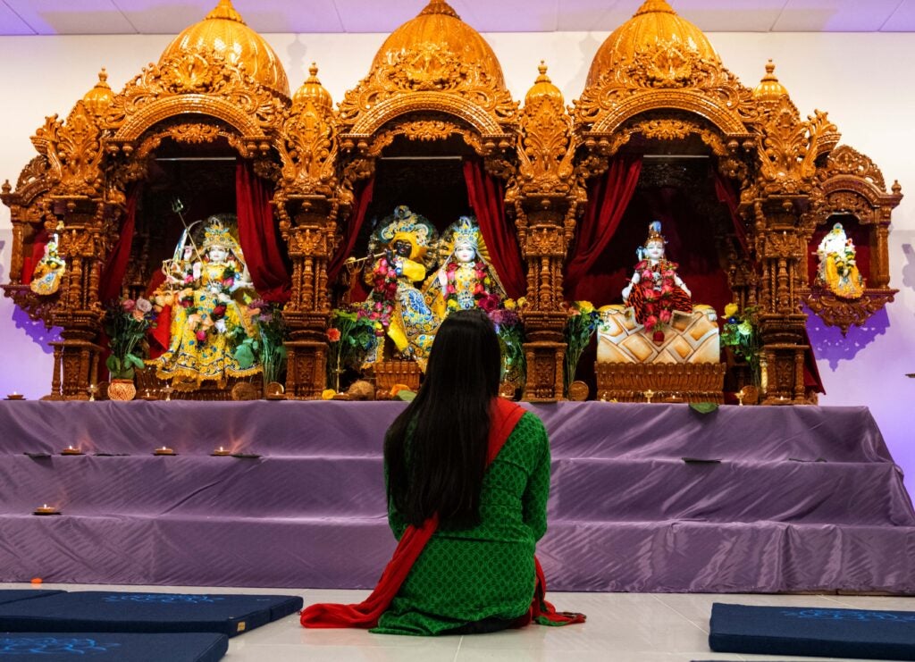 Woman sitting before a shrine.