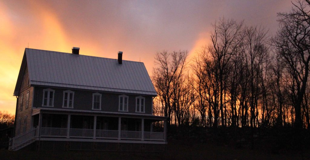 The house at the Contemplative Center with a glowing sunset