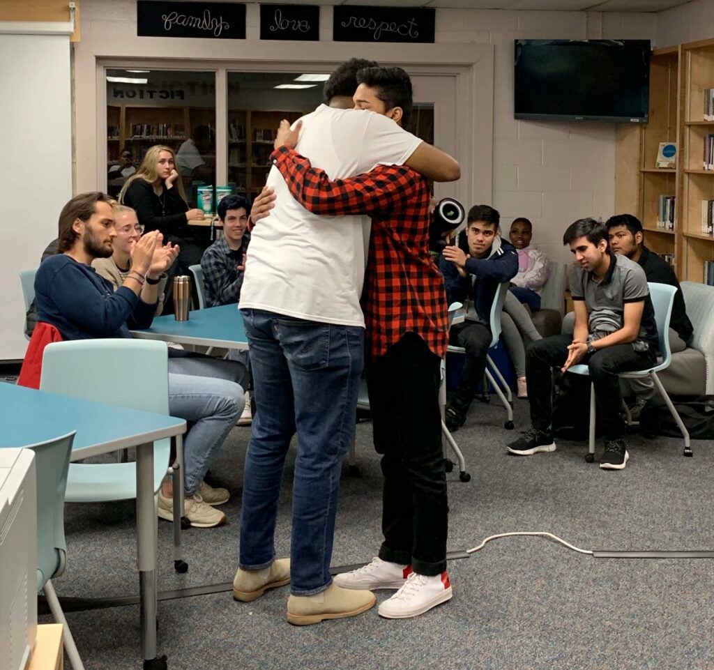 Jerome embracing a student after they shared their story as part of the SmallTalk Storytelling Club.