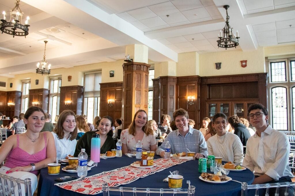 a group of students sitting around a dinner table at Rosh Hashana