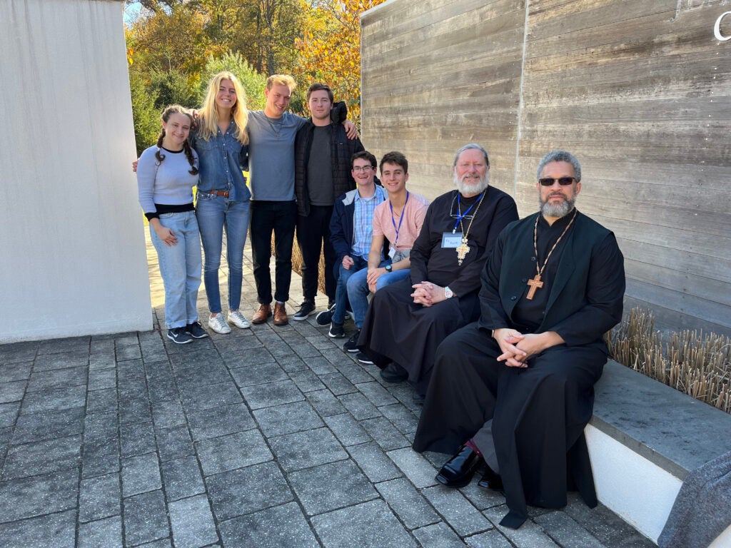 six students gathered together outdoors with Orthodox priests