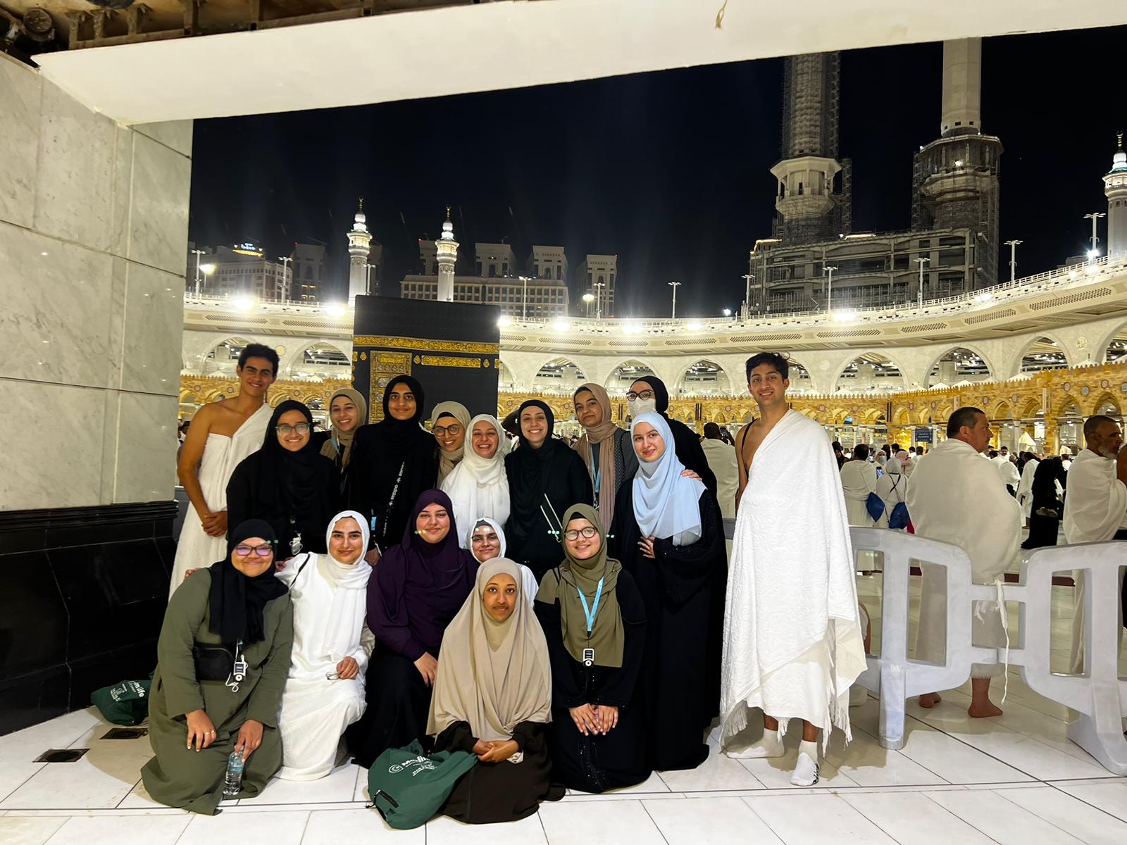 The Kaaba a stone building at the center of Islam's most important mosque and holiest site stands behind a group of muslim women with two muslim