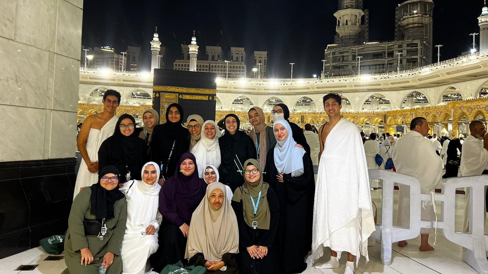 The Kaaba a stone building at the center of Islam's most important mosque and holiest site stands behind a group of muslim women with two muslim