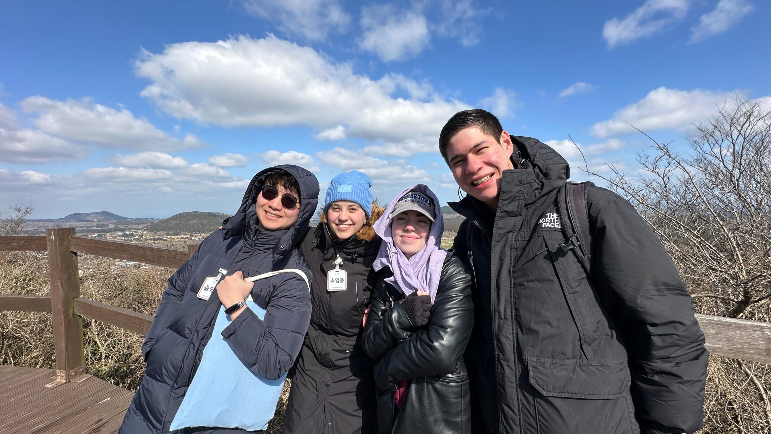 4 classmates pose for picture during hike on mountain. 