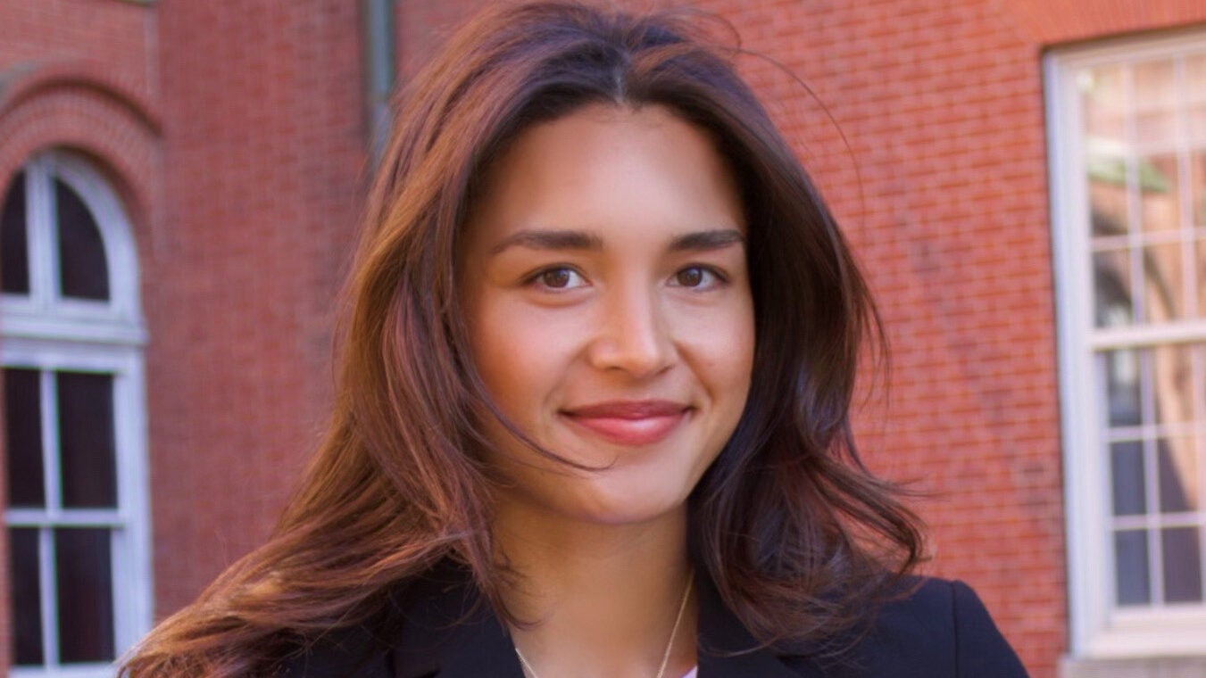 Headshot of a young woman wearing a dark colored blazer and white top.