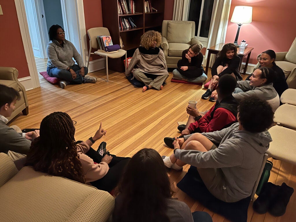 Students and Rev. Ebony Grison sitting in a circle during a group reflection exercise