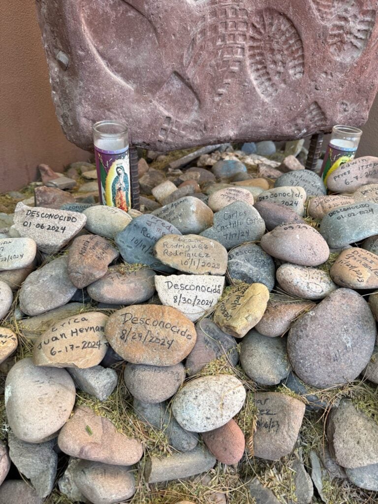a collection of rocks with names and dates left as reminders of people who came to the border. 
