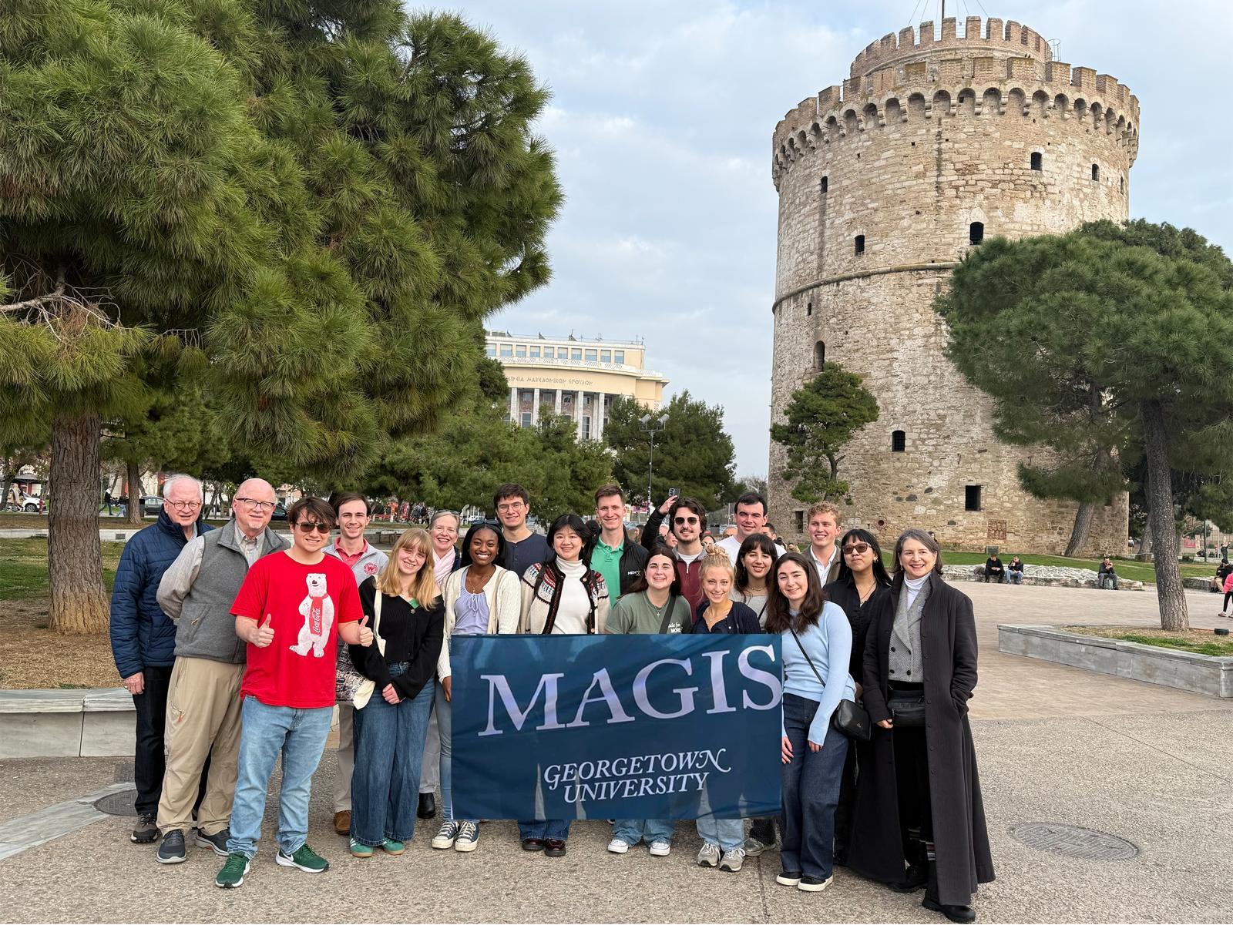 A group of students holding a Magis flag. 