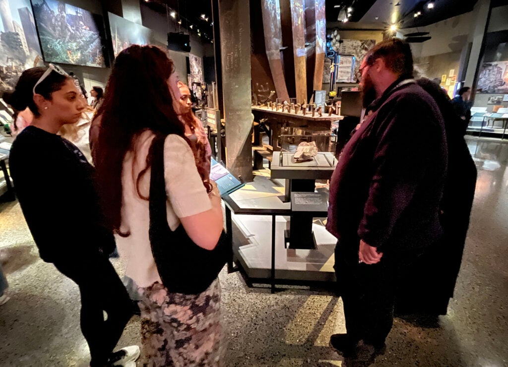 a group of people are gathered around an exhibit at a museum